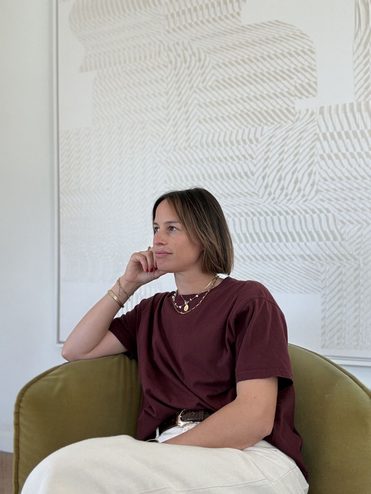 Judith zit peinzend in een zetel voor een licht kunstwerk
